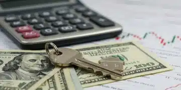 House key on dollar bills with interest rate graph, symbolizing mortgage refinancing decisions.